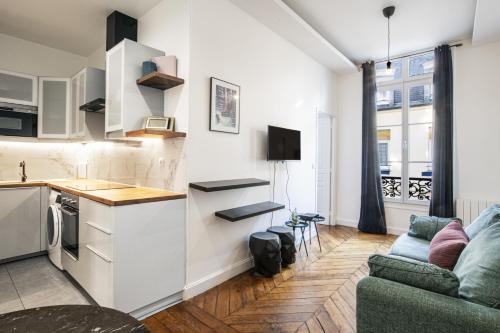 une cuisine et un salon avec un canapé dans l'établissement Pick A Flat's Apartements in Louvre-Rivoli - Rue du Roule, à Paris