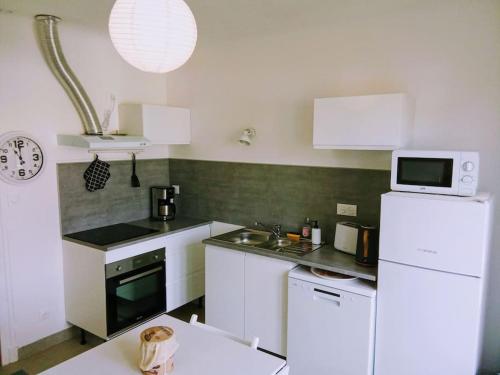 a kitchen with white appliances and a white refrigerator at charmante maison près du centre ville in Amboise
