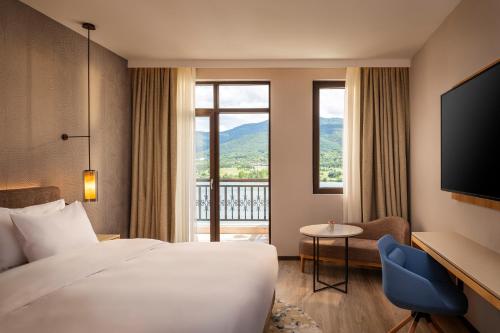 a hotel room with a bed and a large window at Hyatt Regency Pravets Resort in Pravets