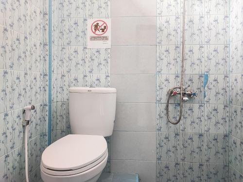 uma casa de banho com WC e uma placa na parede em RedDoorz Plus Syariah near Simpang Rimbo Jambi em Kinati