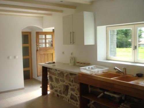 a kitchen with a sink and a stone wall at Captivating 2-Bed House with log burner in Kerien in Kérien