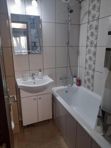 een badkamer met een wastafel, een bad en een douche bij Apartament Claudia in Deva