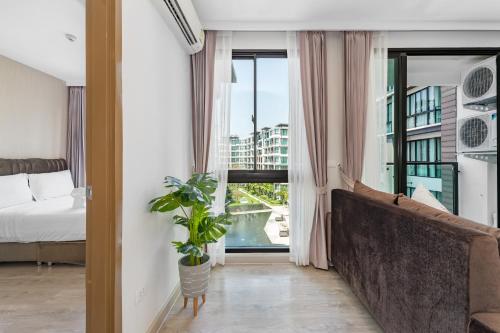 a bedroom with a bed and a large window at Wyndham Royal Lee Phuket in Nai Yang Beach