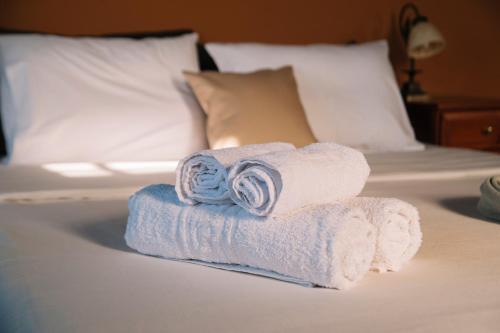 a stack of towels sitting on a bed at Pliades Traditional Guesthouse in Palaios Panteleimon