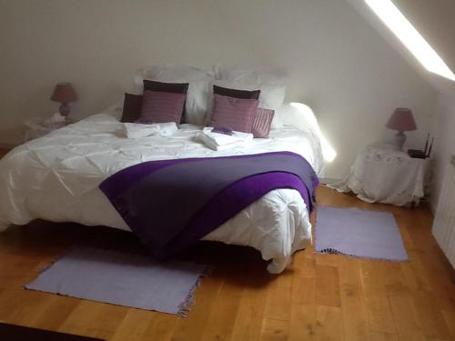 - une chambre dotée d'un grand lit avec des draps et des oreillers violets dans l'établissement Captivating 2-Bed House with log burner in Kerien, à Kérien