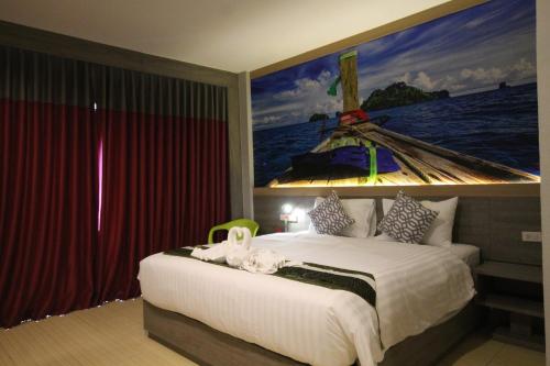 a bedroom with a bed with a painting of a boat at KRABI CHARM in Ban Khlong Haeng