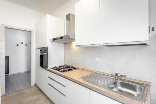 a kitchen with white cabinets and a sink at [House Near Train Station]A/C in Seriate
