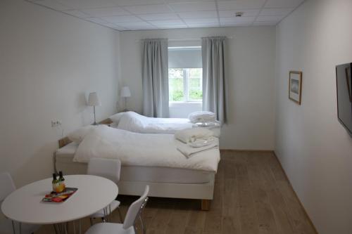 um quarto branco com uma cama e uma mesa em AK Apartments em Akureyri