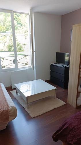 ein Wohnzimmer mit einem Couchtisch vor einem Fenster in der Unterkunft studio en face des salines in Salins-les-Bains