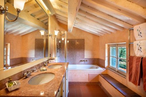 y baño con 2 lavabos y bañera. en Villa Igea 8, en Mastiano