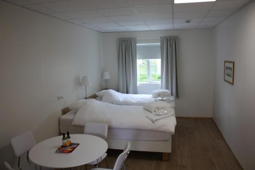 a bedroom with a bed and a table and chairs at AK Apartments in Akureyri
