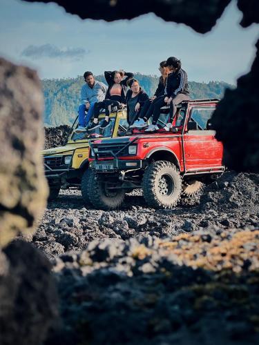 a group of people riding in the back of toy trucks at Batur Volcano Guesthouse in Kintamani
