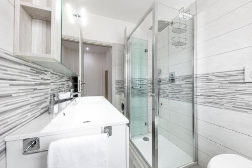 La salle de bains est pourvue d'une douche en verre et d'un lavabo. dans l'établissement [House Near Train Station]A/C, à Seriate