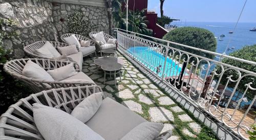 a balcony with white chairs and a swimming pool at Hotel Marincanto in Positano