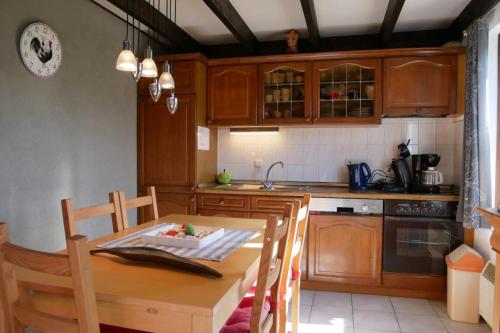 uma cozinha com armários de madeira e uma mesa de madeira com cadeiras em Zeepolder I 38 em De Haan