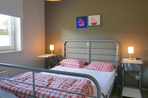 een slaapkamer met een bed met 2 rode kussens bij Green Garden XV 0004 in De Haan