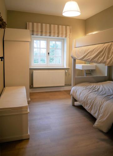 a bedroom with a bunk bed and a window at Edelweis in De Haan