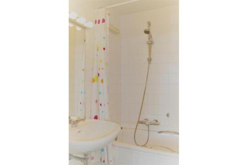 uma casa de banho com um chuveiro, um lavatório e uma banheira em Golf & Beach B3 em De Haan