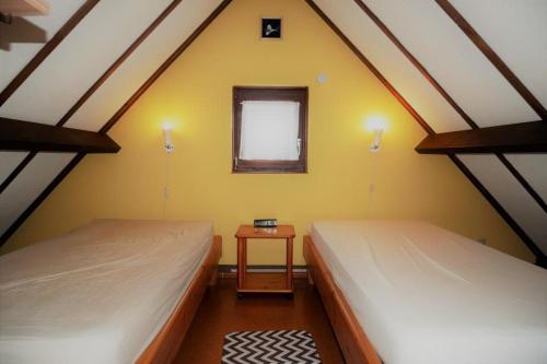 2 Betten in einem Zimmer mit einem Fenster und einem Tisch in der Unterkunft Zeewind I 46 in Bredene