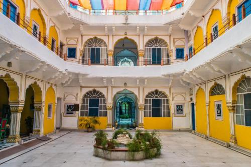 Diggi Palace - A City Center Hidden Heritage Gem في جايبور: غرفة بجدران صفراء وسقف مع نافورة