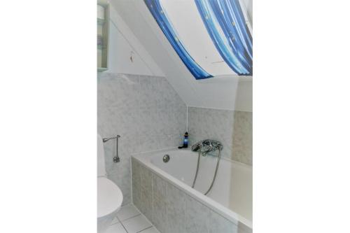 uma casa de banho com uma banheira e um lavatório em Achter N Diek em De Haan