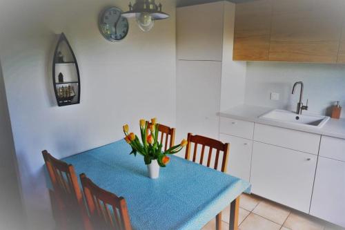 a kitchen with a table with a vase of flowers on it at Zeewind II 112 in Bredene