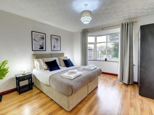 a bedroom with a large bed and a window at Terracotta House I Executive House I Parking and Pet Friendly I eco-Short Term Let by SILVA in Clapham