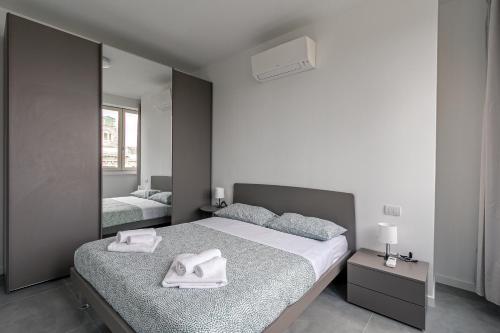 een slaapkamer met een bed en een grote spiegel bij IM HOME - NAPO TORRIANI STAZIONE CENTRALE in Milaan