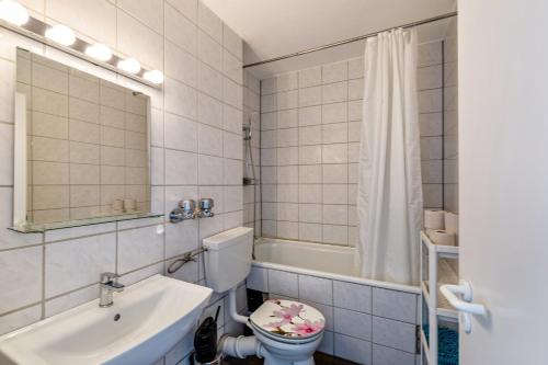 La salle de bains est pourvue d'un lavabo, de toilettes et d'un miroir. dans l'établissement Good And Night, à Neuss