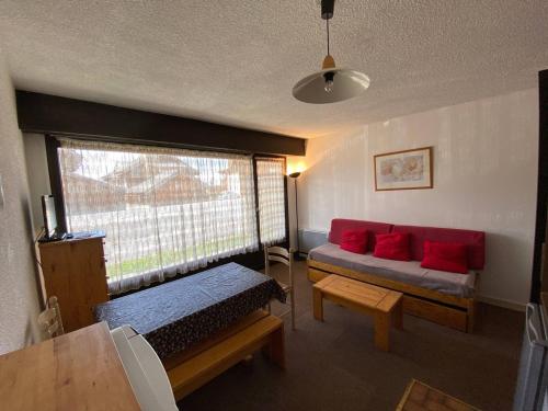 - un salon avec un canapé rouge et une fenêtre dans l'établissement Studio cosy pour 4 pers, centre Alpe d'Huez, proche pistes, animaux OK, terrasse sud - FR-1-405-48, à L'Alpe-d'Huez