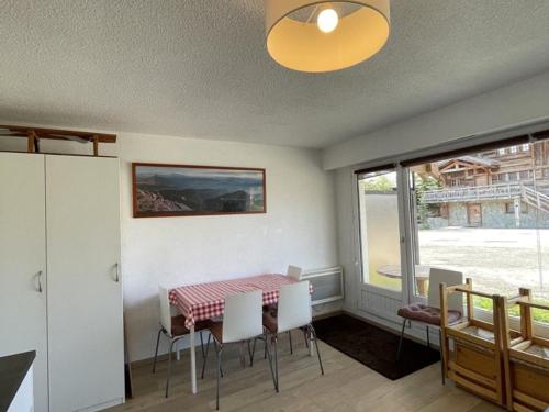 une salle à manger avec une table et des chaises et une fenêtre dans l'établissement Studio confortable au centre de l'Alpe d'Huez, près des pistes et commerces - 4 pers, terrasse sud - FR-1-405-123, à L'Alpe-d'Huez