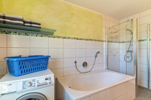 a bathroom with a tub and a washing machine at Im Rosengarten in Zell am Harmersbach