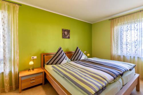 a green bedroom with a bed and a window at Im Rosengarten in Zell am Harmersbach