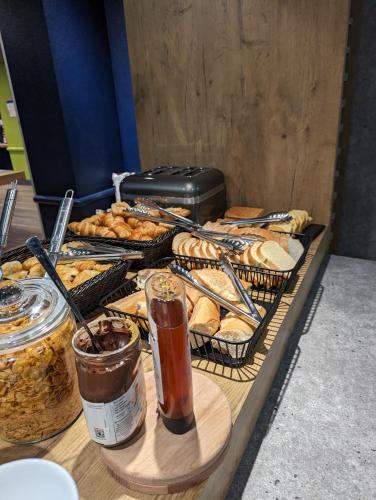 a table with various types of bread and pastries at ibis budget Saint-Omer Centre in Saint-Omer