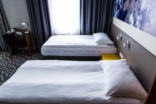 a hotel room with two beds and a window at ibis Styles Warszawa West in Mory