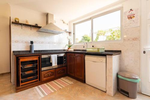 a kitchen with a stove and a sink and a window at Noite's House I - Prazeres in Prazeres