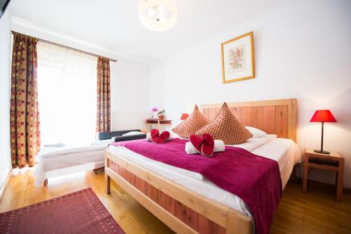 a bedroom with a large bed with red pillows at Pensiunea Turistica Villa Ermitage in Buşteni