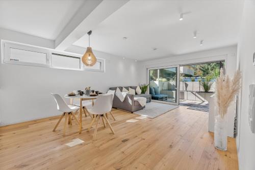 a dining room and living room with a table and chairs at NEU: Stylische Suite mit Netflix und Workspace in Böblingen