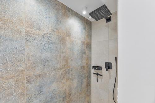 y baño con ducha y pared de piedra. en NEU: Stylische Suite mit Netflix und Workspace, en Böblingen