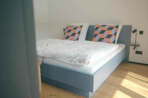 a small bed in a room with a blue frame at CELLA Apartments **** in Zell im Wiesental