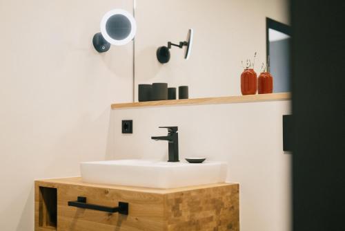 a bathroom with a sink on a wooden stand with a mirror at CELLA Apartments **** in Zell im Wiesental