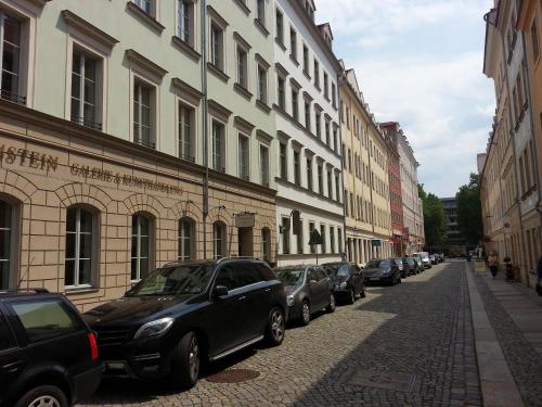 a row of cars parked on a street next to buildings at Apartments Obergraben in Dresden