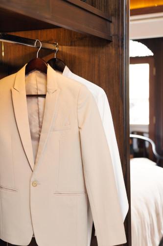 a white suit and tie on a hanger at CHINO@NIMMAN Luxury Boutique Hotel in Chiang Mai