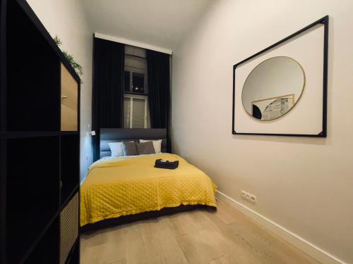 a bedroom with a yellow bed and a mirror at Spacious Apart in the Center- Main Square 300m in Wrocław