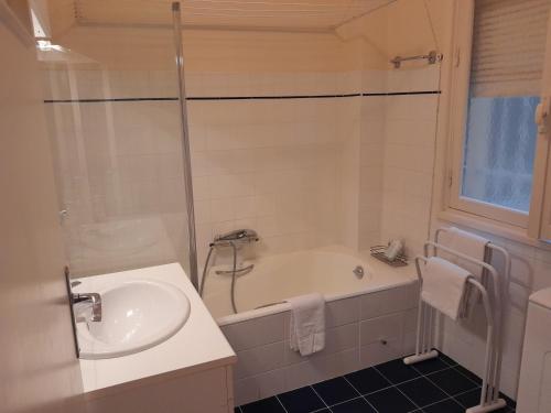 une salle de bain avec un lavabo et une baignoire dans l'établissement Georges Clémenceau Appartment Cannes, à Cannes