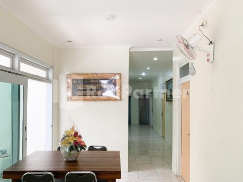 a dining room with a table and a mirror at Oma Uti Syariah Mitra RedDoorz near Stasiun Lempuyangan in Sentool