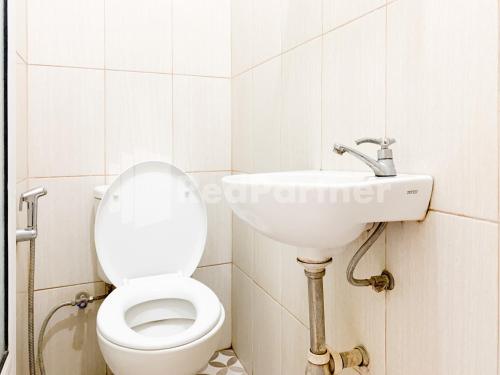 a bathroom with a toilet and a sink at Oma Uti Syariah Mitra RedDoorz near Stasiun Lempuyangan in Sentool