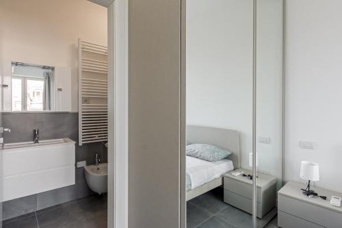 een badkamer met een bed, een wastafel en een spiegel bij IM HOME - NAPO TORRIANI STAZIONE CENTRALE in Milaan