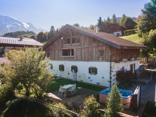 een groot houten huis met een tuin met een tafel bij Wanderful Life MontBlanc refuge haut de gamme in Saint-Gervais-les-Bains