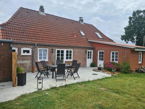 a patio with a table and chairs in front of a house at Ferienhaus Hanne Herrmann Hus in Esgrus